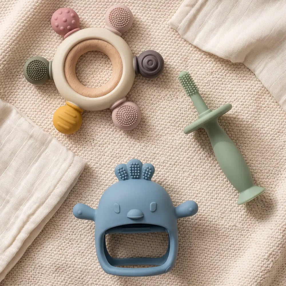 Gentle Start Trio: Sensory, Bristle and Long-Hold Handle Teethers laid out on a knitted blanket