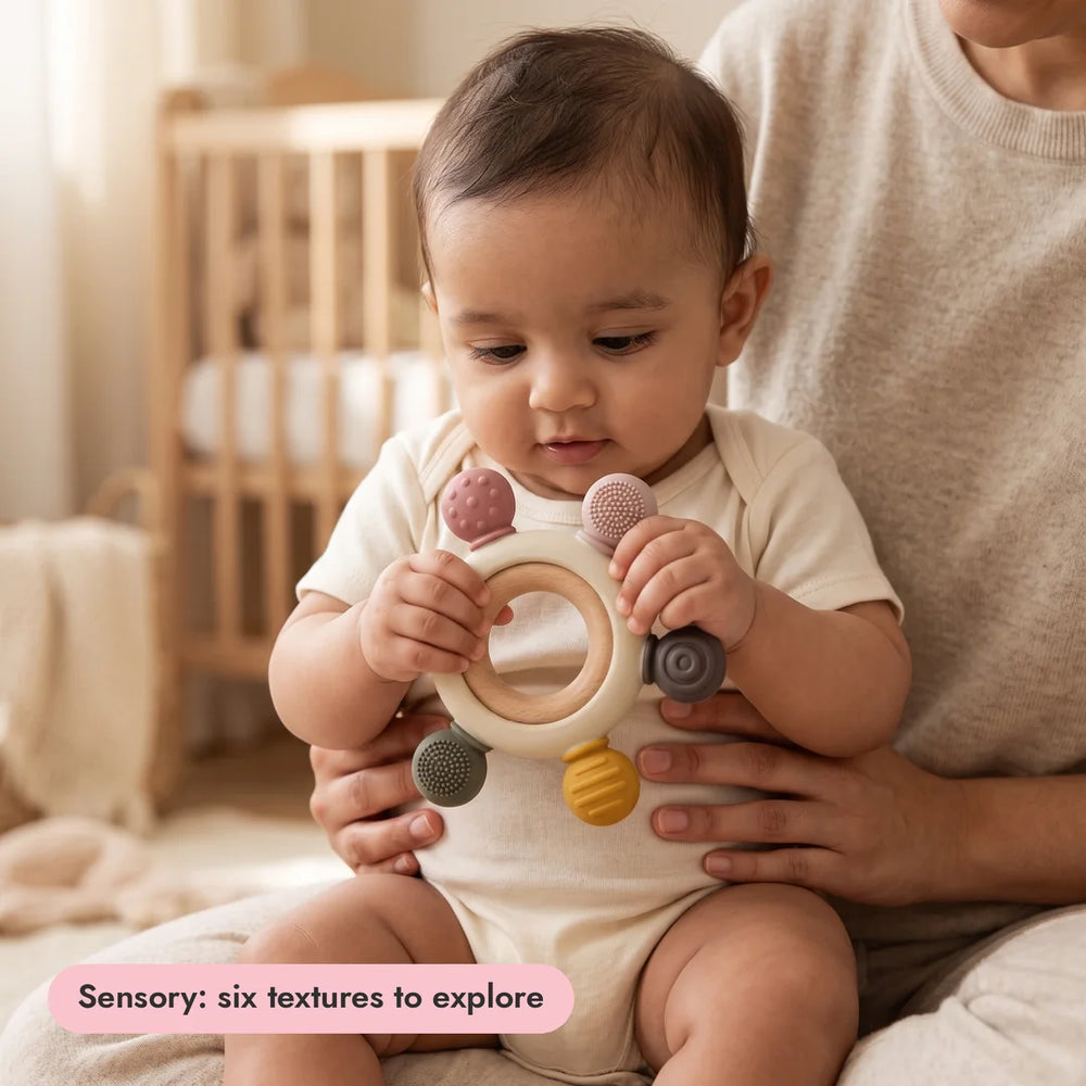 Baby holding the Sensory Teether from the Gentle Start Trio