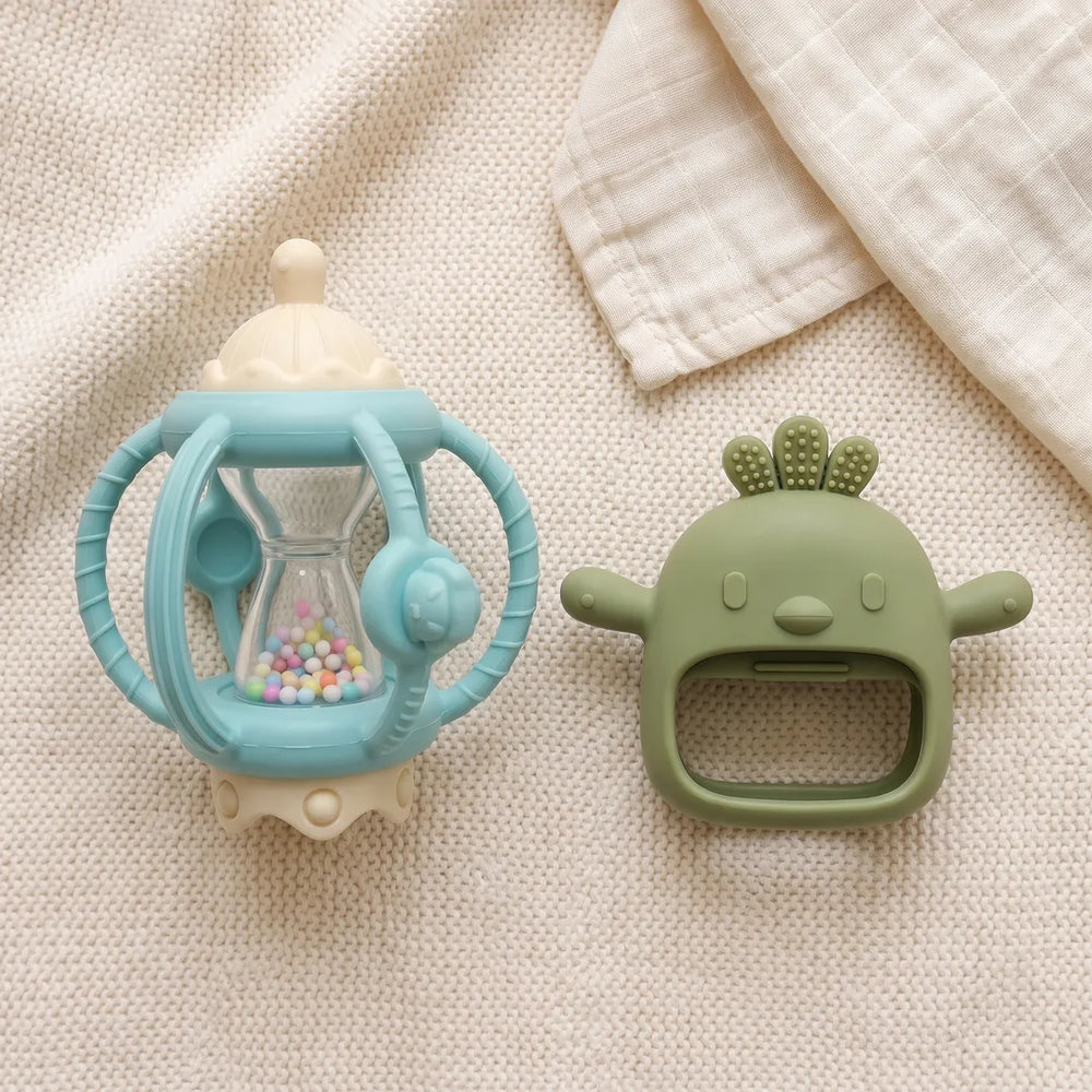 Grip & Rattle Pair teethers laid out on a knitted blanket