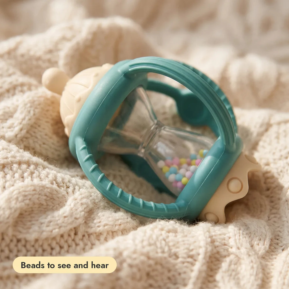 Close-up of a Grip & Rattle Pair teether texture on a knitted blanket